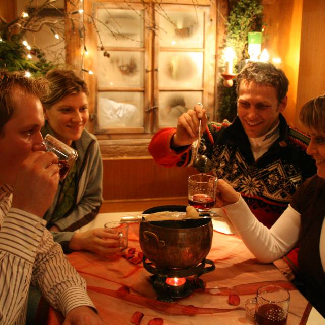 Freunde trinken Feuerzangbowle im Berghotel Talblick