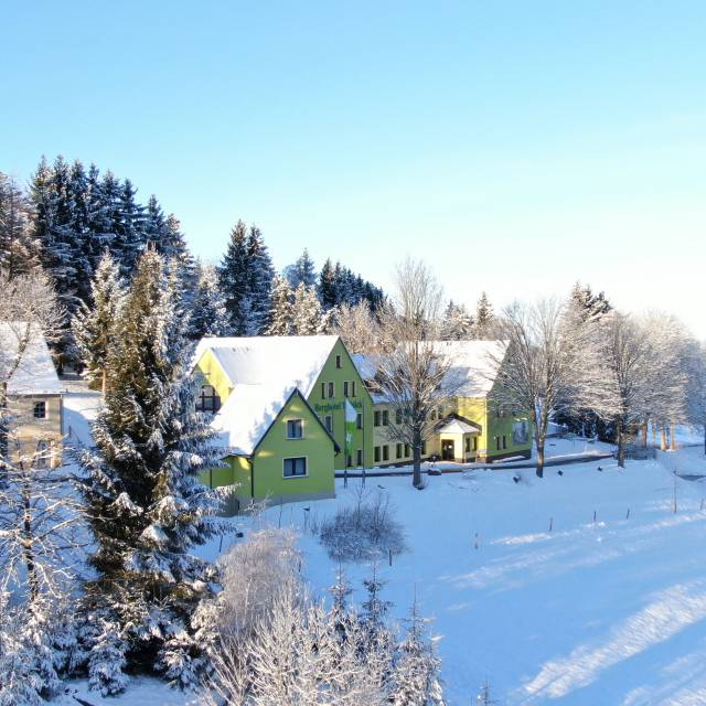 Verschneites Hotel mit Blick auf den Wald