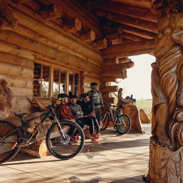Mountainbiker auf Holzhütte mit Blick auf die Berge